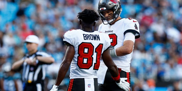 Tom Brady #12 of the Tampa Bay Buccaneers reacts with Antonio Brown #81 during the second half of the game against the Carolina Panthers at Bank of America Stadium on Dec. 26, 2021 in Charlotte, North Carolina.